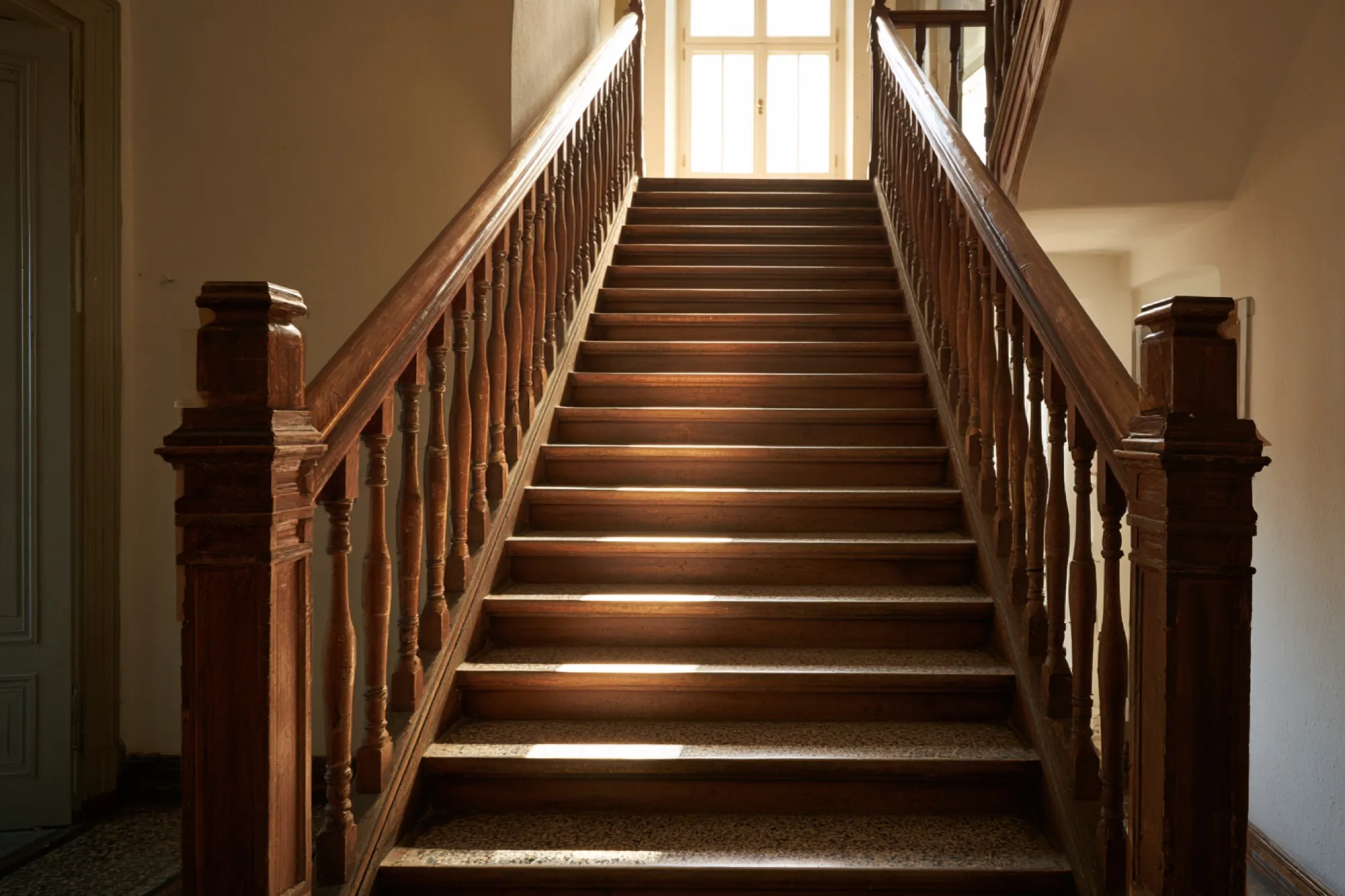 Altbau-Treppenhaus mit Holzgeländer im Haus der vermieteten Wohnung, die verkauft wird